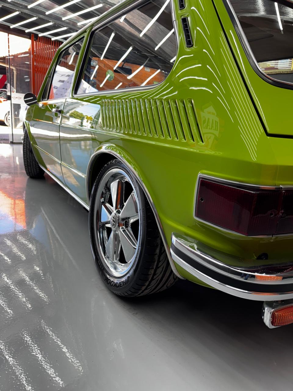 Detalhe traseiro da Brasília verde com reflexos na pintura